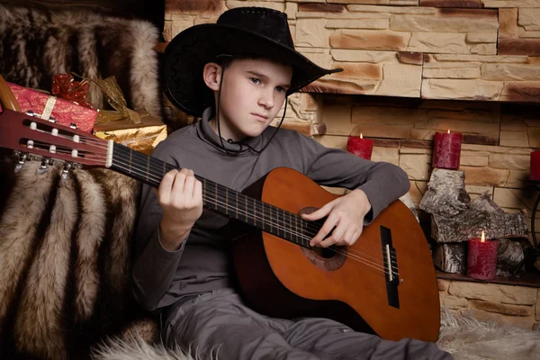 Knappe gelukkige jongen speelt op akoestische gitaar — Stockfoto