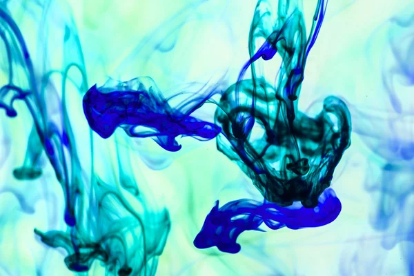 Blue and violet liquid in water making abstract forms — Stock Photo, Image
