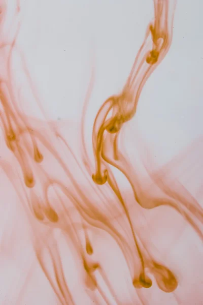 Blaue und violette Flüssigkeit im Wasser, die abstrakte Formen bildet — Stockfoto