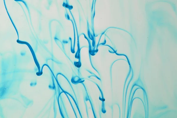 Μπλε και ιώδης υγρό στο νερό κάνοντας αφηρημένες φόρμες — Φωτογραφία Αρχείου