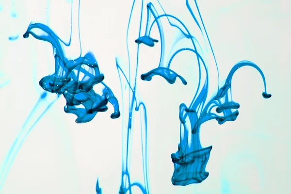 Синьо-фіолетова рідина у воді робить абстрактні форми — стокове фото