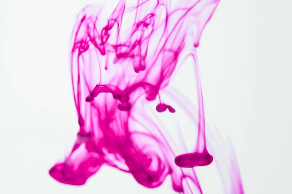 Синяя и фиолетовая жидкости в воде, образующие абстрактные формы — стоковое фото