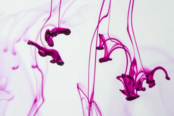 Líquido azul y violeta en agua haciendo formas abstractas —  Fotos de Stock