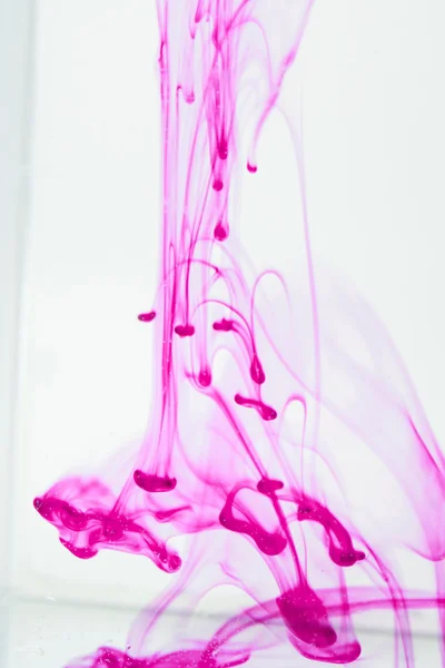 Синяя и фиолетовая жидкости в воде, образующие абстрактные формы — стоковое фото