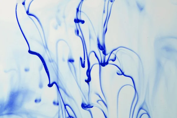 Blue and violet liquid in water making abstract forms — Stock Photo, Image