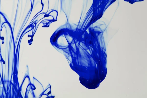 Синьо-фіолетова рідина у воді робить абстрактні форми — стокове фото