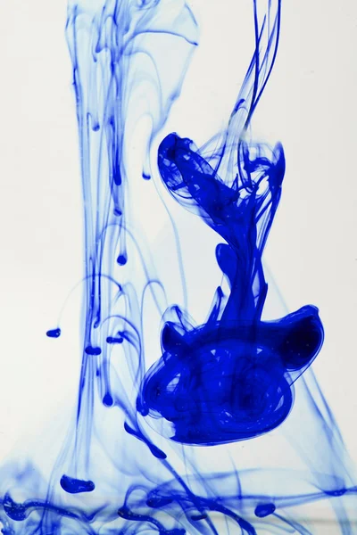 Blue and violet liquid in water making abstract forms — Stock Photo, Image