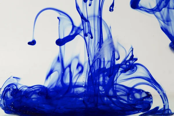 Blue and violet liquid in water making abstract forms — Stock Photo, Image