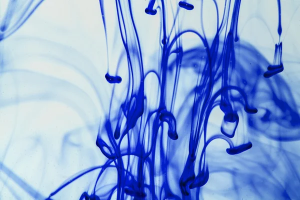 Blauw en violet vloeistof in water waardoor abstracte vormen — Stockfoto