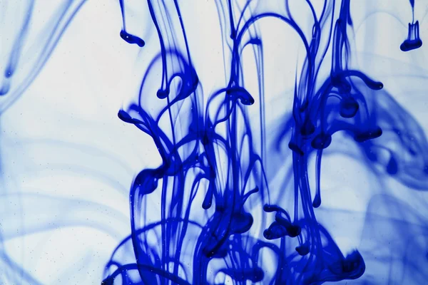 Blue and violet liquid in water making abstract forms — Stock Photo, Image