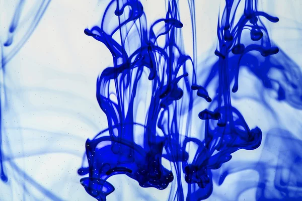 Blue and violet liquid in water making abstract forms — Stock Photo, Image