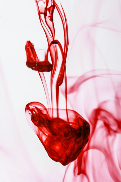 Red ink liquid in water making abstract forms