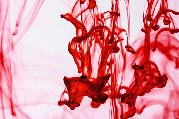 Синяя и фиолетовая жидкости в воде, образующие абстрактные формы
 