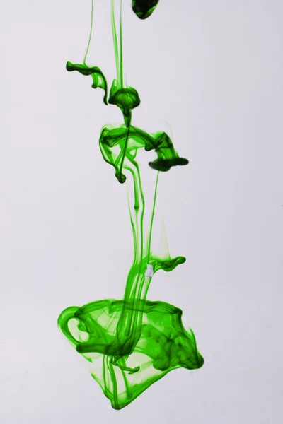 Green liquid ink in water making abstract forms — Stock Photo, Image