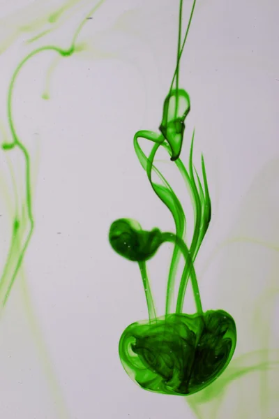 Tinta líquida verde em água fazendo formas abstratas — Fotografia de Stock