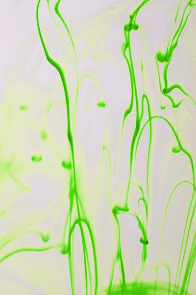 Зеленые жидкие чернила в воде, образующие абстрактные формы — стоковое фото