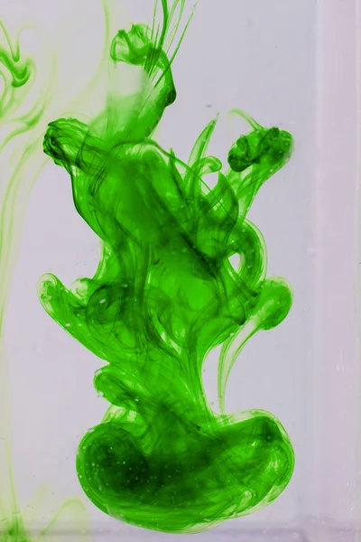 Green liquid ink in water making abstract forms — Stock Photo, Image