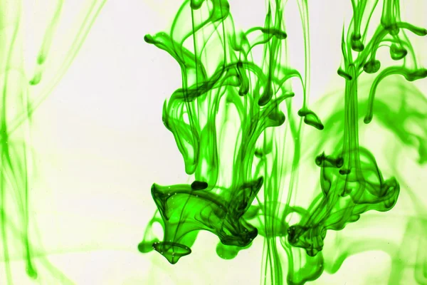 Green liquid ink in water making abstract forms — Stock Photo, Image