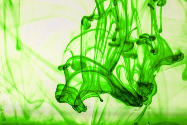 Green liquid ink in water making abstract forms — Stock Photo, Image