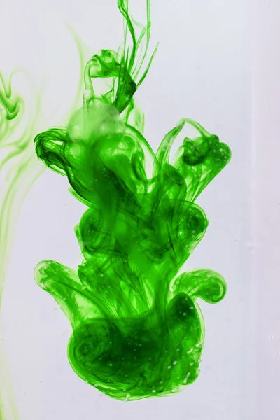 Green liquid ink in water making abstract forms — Stock Photo, Image