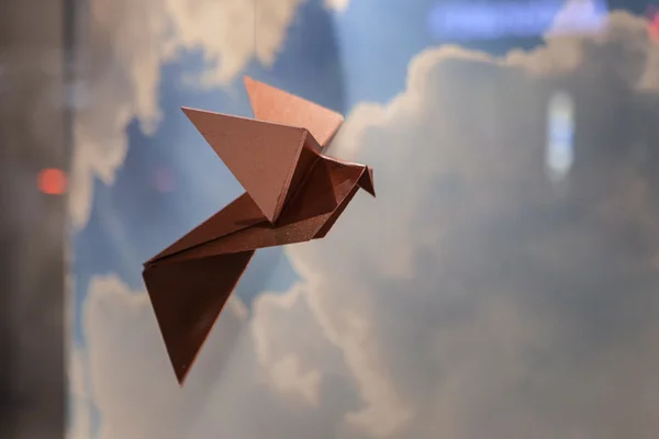 Origami fliegen auf Himmel Hintergrund — Stockfoto