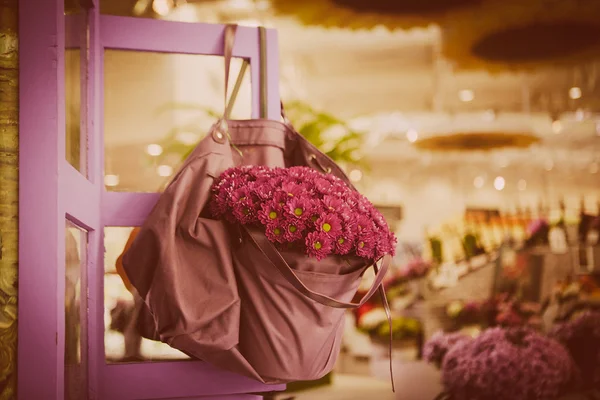 Violet flowers in bag — Stock Photo, Image