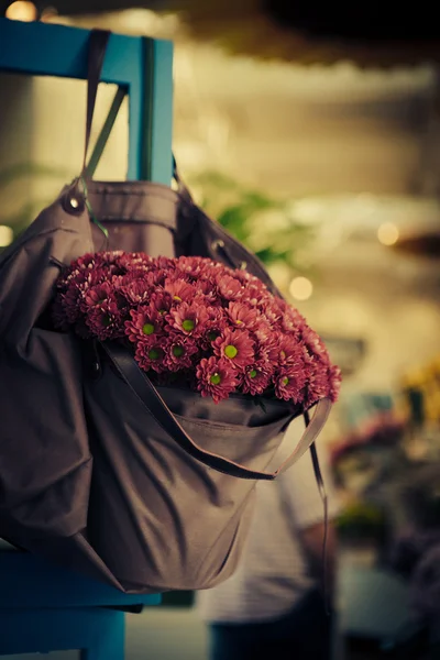 Violet flowers in bag — Stock Photo, Image