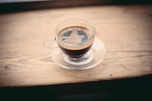 Una taza de café sobre una mesa de madera — Foto de Stock