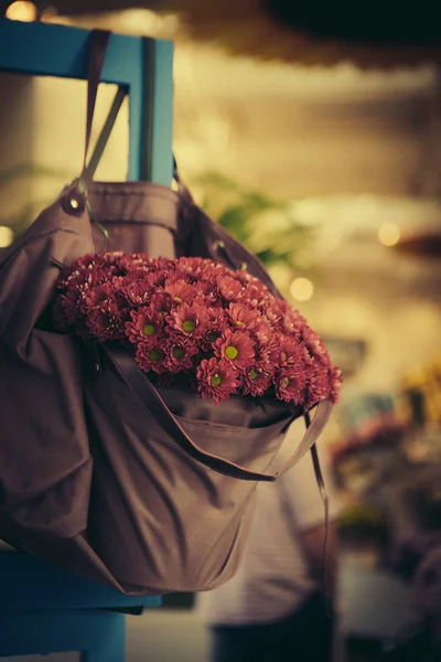 Violet flowers in bag — Stock Photo, Image