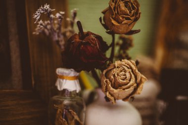 Vintage tarzı natürmort üç kurutulmuş gül ve şişe
