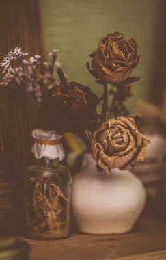 Vintage tarzı natürmort üç kurutulmuş gül ve şişe