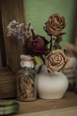 Vintage tarzı natürmort üç kurutulmuş gül ve şişe