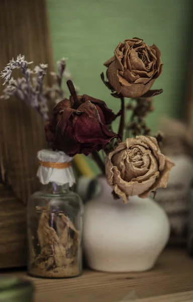 Estilo vintage ainda vida com três rosas secas e garrafa — Fotografia de Stock
