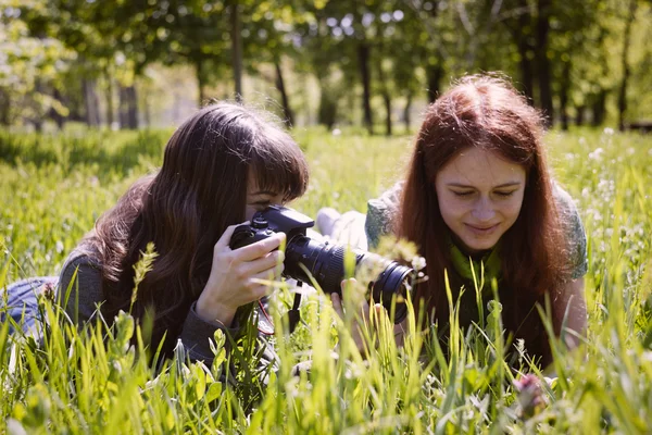 Two girls in spring park with photo camera — Stock Photo, Image