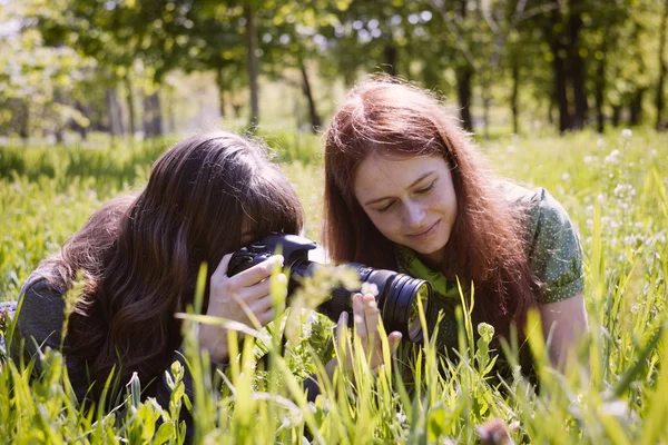 Två tjejer i vår park med fotokamera — Stockfoto