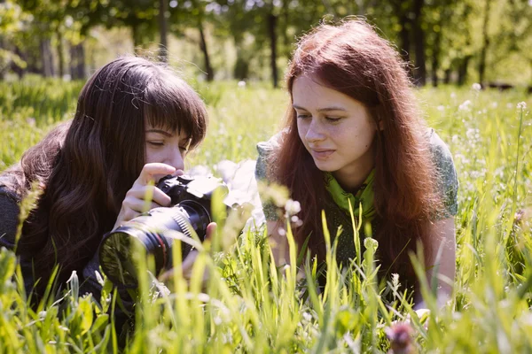 Две девушки в весеннем парке с фотоаппаратом — стоковое фото