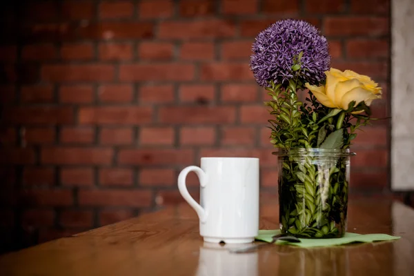 Tazza di caffè e bellissimi fiori su sfondo di legno — Foto Stock