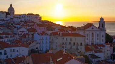 Lizbon 'un ikonik kırmızı kiremitli çatılarının çarpıcı bir panoramik gün doğumu görüntüsü, güneş doğarken tarihi mimari