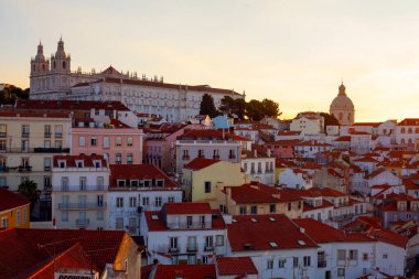 Lizbon, Portekiz - 27 Temmuz 2025: Lizbon 'un ikonik kırmızı kiremitli çatılarının çarpıcı bir panoramik gün doğumu görüntüsü, gündoğumu sırasındaki tarihi mimari