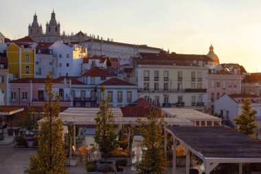 Lizbon, Portekiz - 27 Temmuz 2025: Lizbon 'un ikonik kırmızı kiremitli çatılarının çarpıcı bir panoramik gün doğumu görüntüsü, gündoğumu sırasındaki tarihi mimari