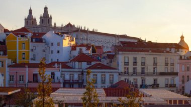 Lizbon, Portekiz - 27 Temmuz 2025: Lizbon 'un ikonik kırmızı kiremitli çatılarının çarpıcı bir panoramik gün doğumu görüntüsü, gündoğumu sırasındaki tarihi mimari