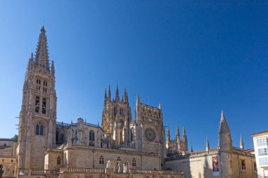 Burgos, İspanya - 15 Temmuz 2025: Güneşli bir yaz gününde, parlak mavi gökyüzü altında, karmaşık gotik mimarisi ve yükselen kuleleri ile İspanya 'nın Burgos katedraline bakın.