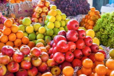 Hindistan sokak pazarında parlak renkli meyveler: elma, portakal, üzüm,