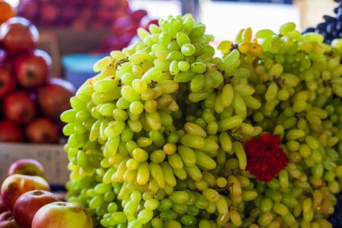 Hindistan 'da sokak pazarında çiçeklerle süslenmiş parlak üzümler.