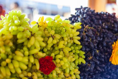 Hindistan 'da sokak pazarında çiçeklerle süslenmiş parlak üzümler.