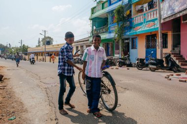PONDICHERRY, INDIA - 20 Ocak 2015: Genç çocuklar Pondicherry Hint kasabasının geleneksel evlerinin önünden bisikletle geçiyorlar