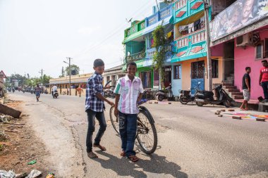 PONDICHERRY, INDIA - 20 Ocak 2015: Genç çocuklar Pondicherry Hint kasabasının geleneksel evlerinin önünden bisikletle geçiyorlar