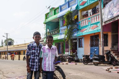 PONDICHERRY, INDIA - 20 Ocak 2015: Genç çocuklar Pondicherry Hint kasabasının geleneksel evlerinin önünden bisikletle geçiyorlar