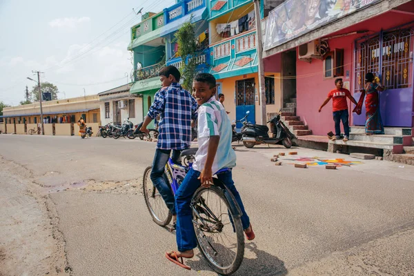PONDICHERRY, INDIA - 20 Ocak 2015: Genç çocuklar Pondicherry Hint kasabasının geleneksel evlerinin önünden bisikletle geçiyorlar