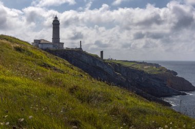  Cape Mayor 'un kayalık Atlantik sahili manzarası güneşli yaz gününde deniz feneriyle, Santander, İspanya.